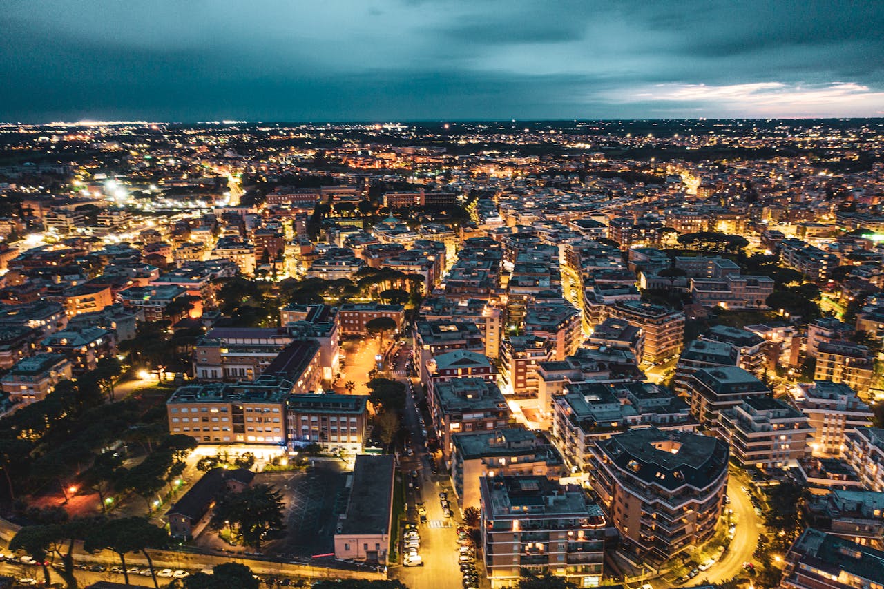 Stunning aerial view of Rome at night showcasing vibrant city lights and architecture.